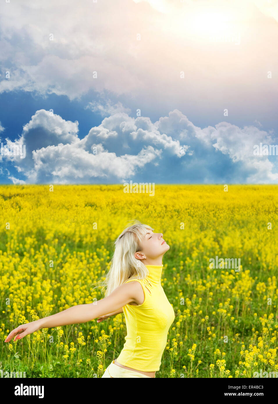 Happy young woman in a flower field Stock Photo - Alamy