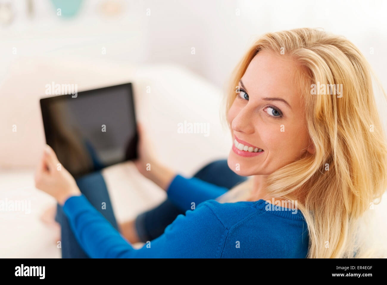 Beautiful young woman using digital tablet on sofa Stock Photo - Alamy