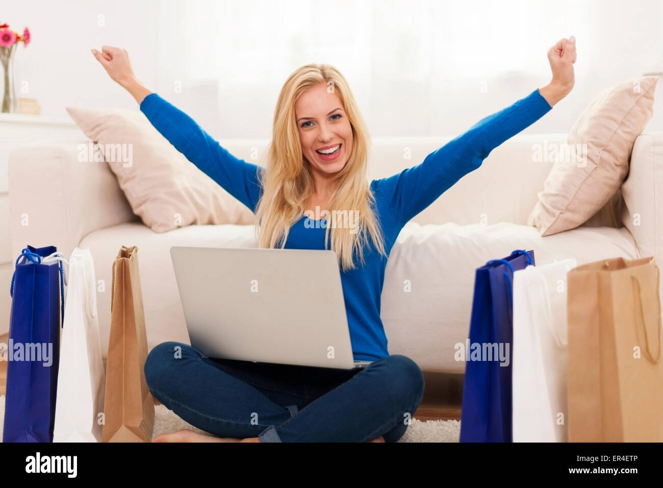 Excited young woman with online shopping Stock Photo