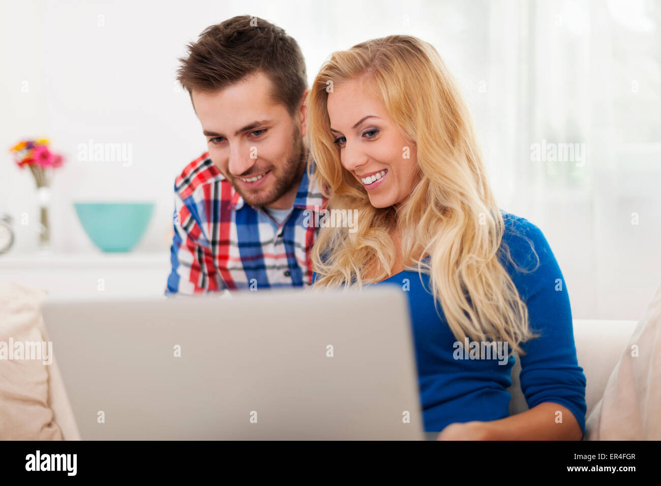 Smiling couple using laptop at home Stock Photo - Alamy