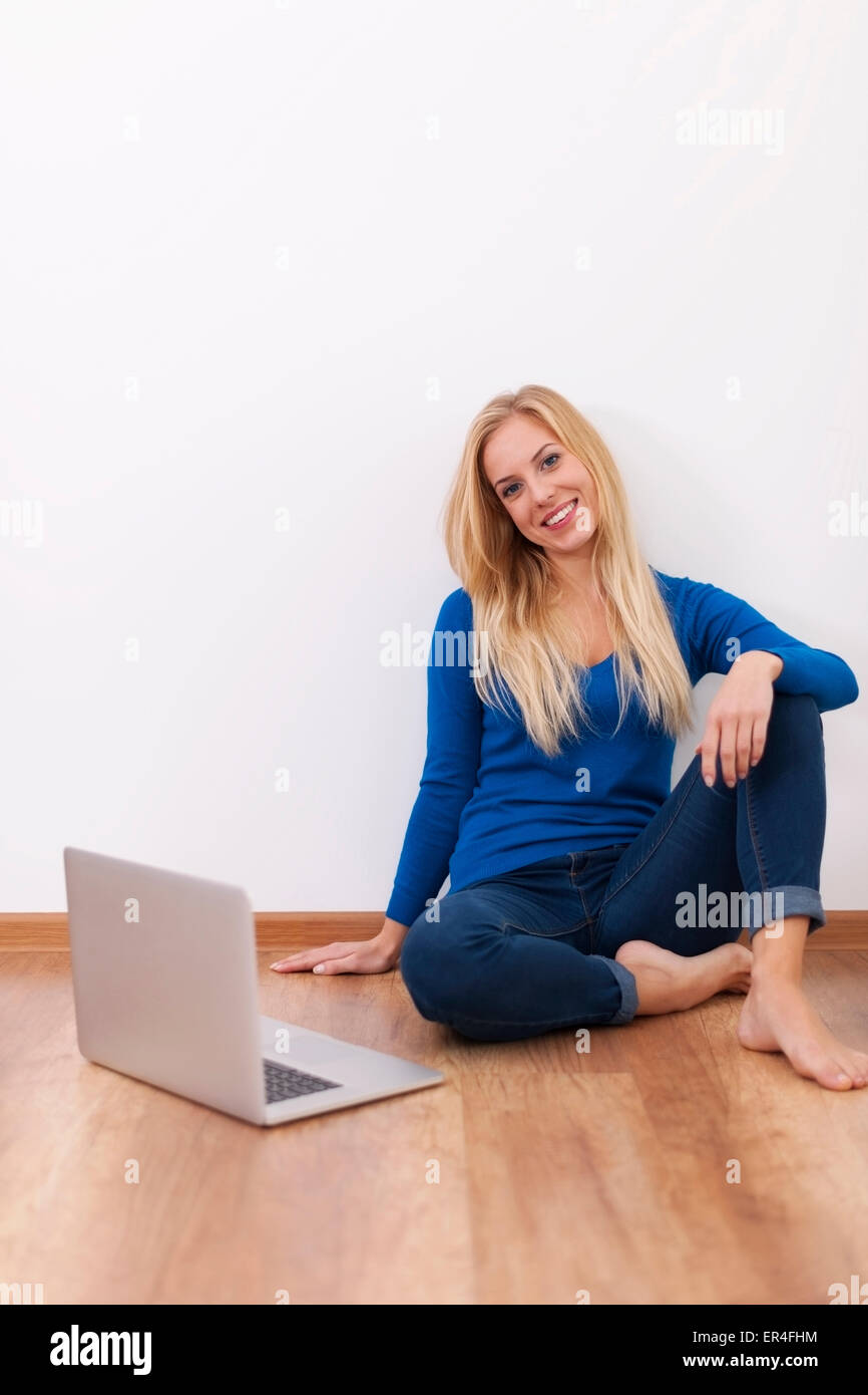 Smiling young woman relaxing with laptop Stock Photo - Alamy
