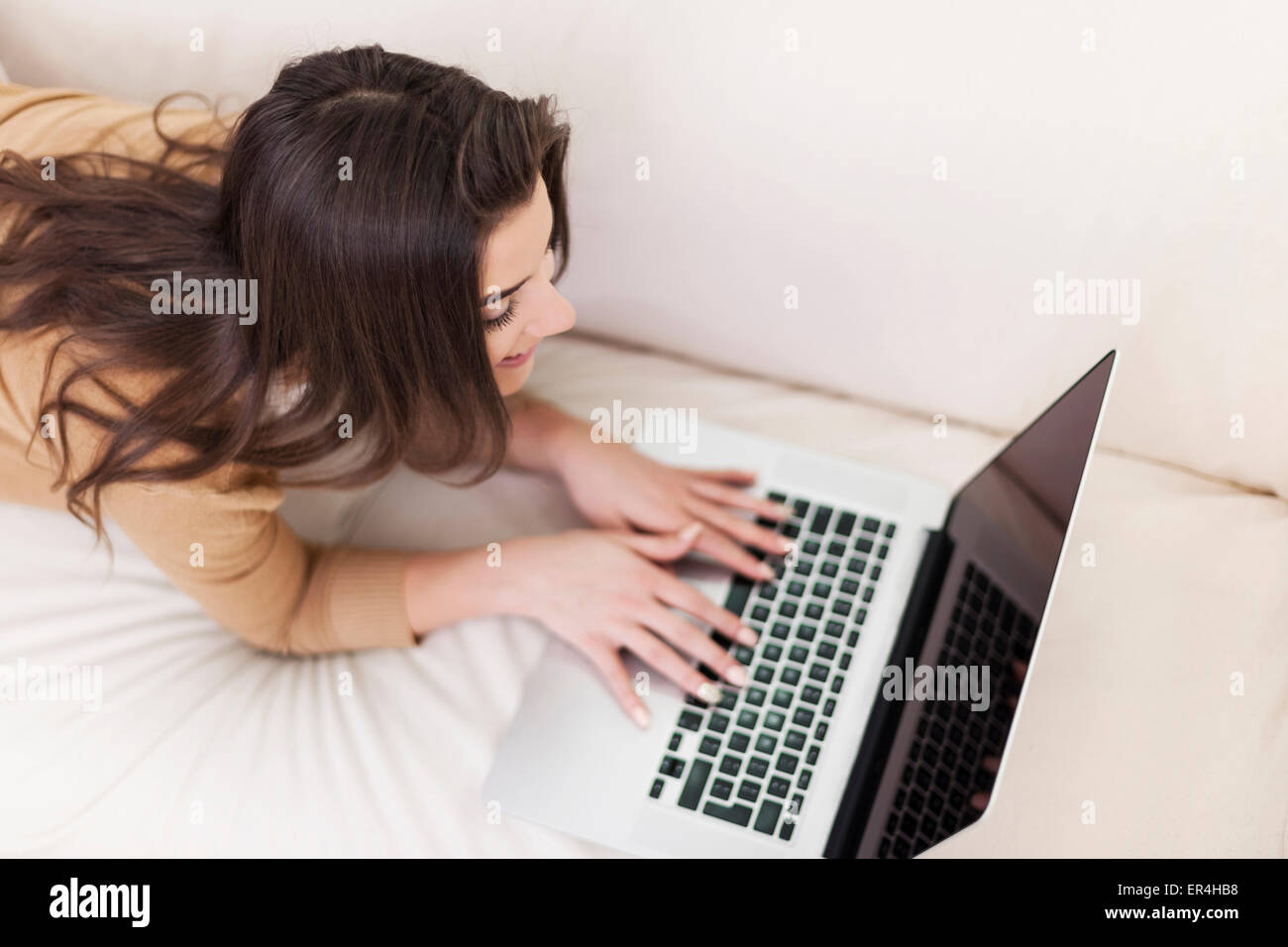 Beautiful woman relaxing with her laptop Stock Photo - Alamy