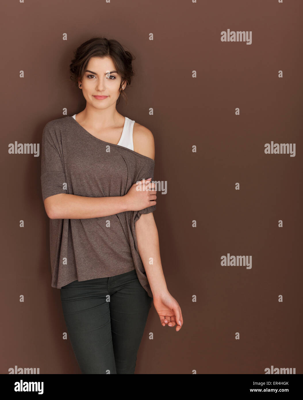 Beautiful woman posing against brown background Stock Photo - Alamy
