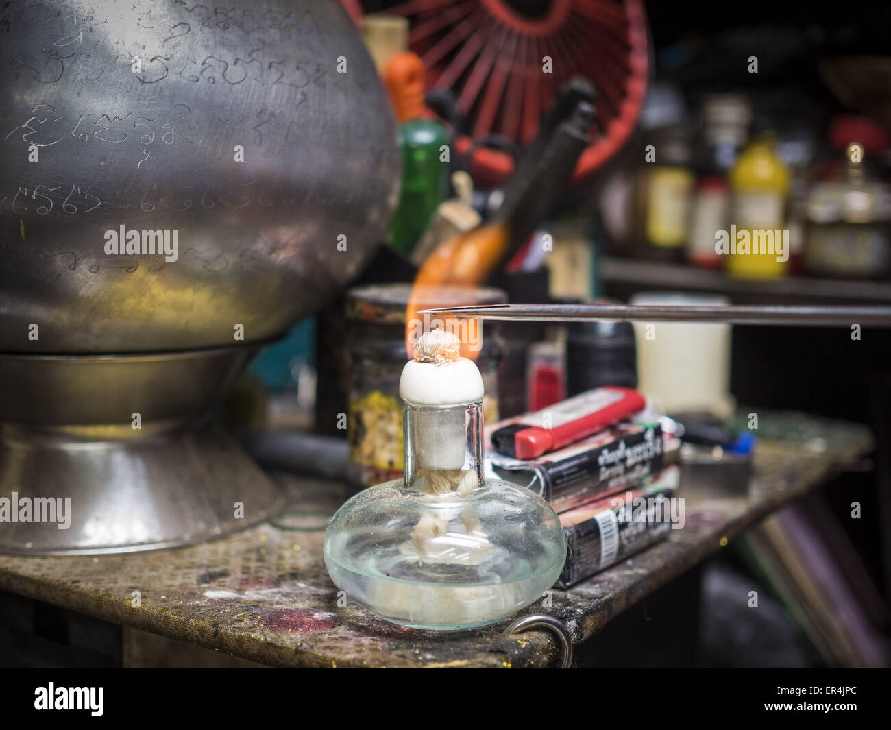 Bangkok, Bangkok, Thailand. 25th May, 2015. A tattoo needle is sterilized in a flame in Ajarn Neng Onnut's Sak Yant tattoo parlor. Sak Yant (Thai for ''tattoos of mystical drawings'' sak=tattoo, yantra=mystical drawing) tattoos are popular throughout Thailand, Cambodia, Laos and Myanmar. The tattoos are believed to impart magical powers to the people who have them. People get the tattoos to address specific needs. For example, a business person would get a tattoo to make his business successful, and a soldier would get a tattoo to help him in battle. Credit:  ZUMA Press, Inc./Alamy Live News Stock Photo