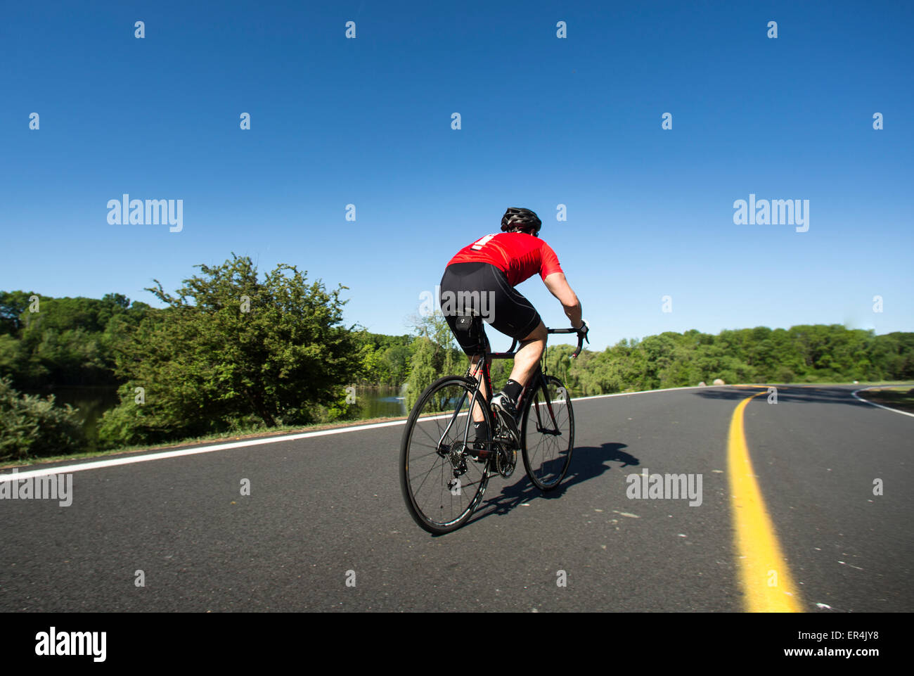 Road Riding Man riding a road bike on a paved roadway Stock Photo - Alamy