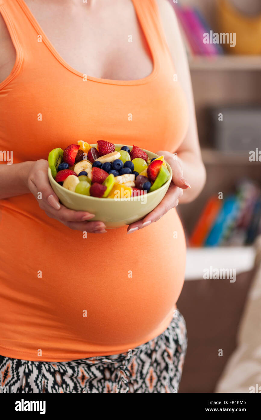 Close up of pregnant woman with fruit salad. Debica, Poland Stock Photo