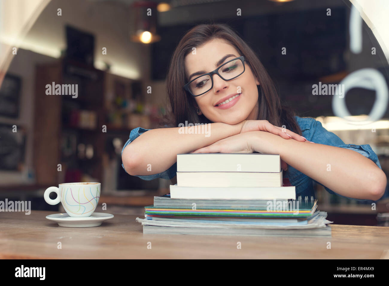 Dreaming and smiling female student at cafe. Krakow, Poland Stock Photo