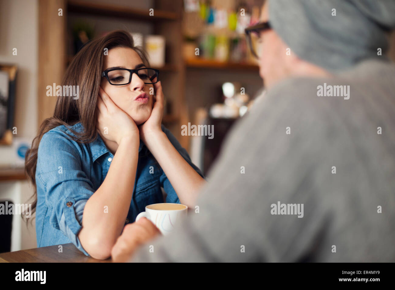Loving woman blowing kisses to her boyfriend at cafe. Krakow, Poland Stock Photo