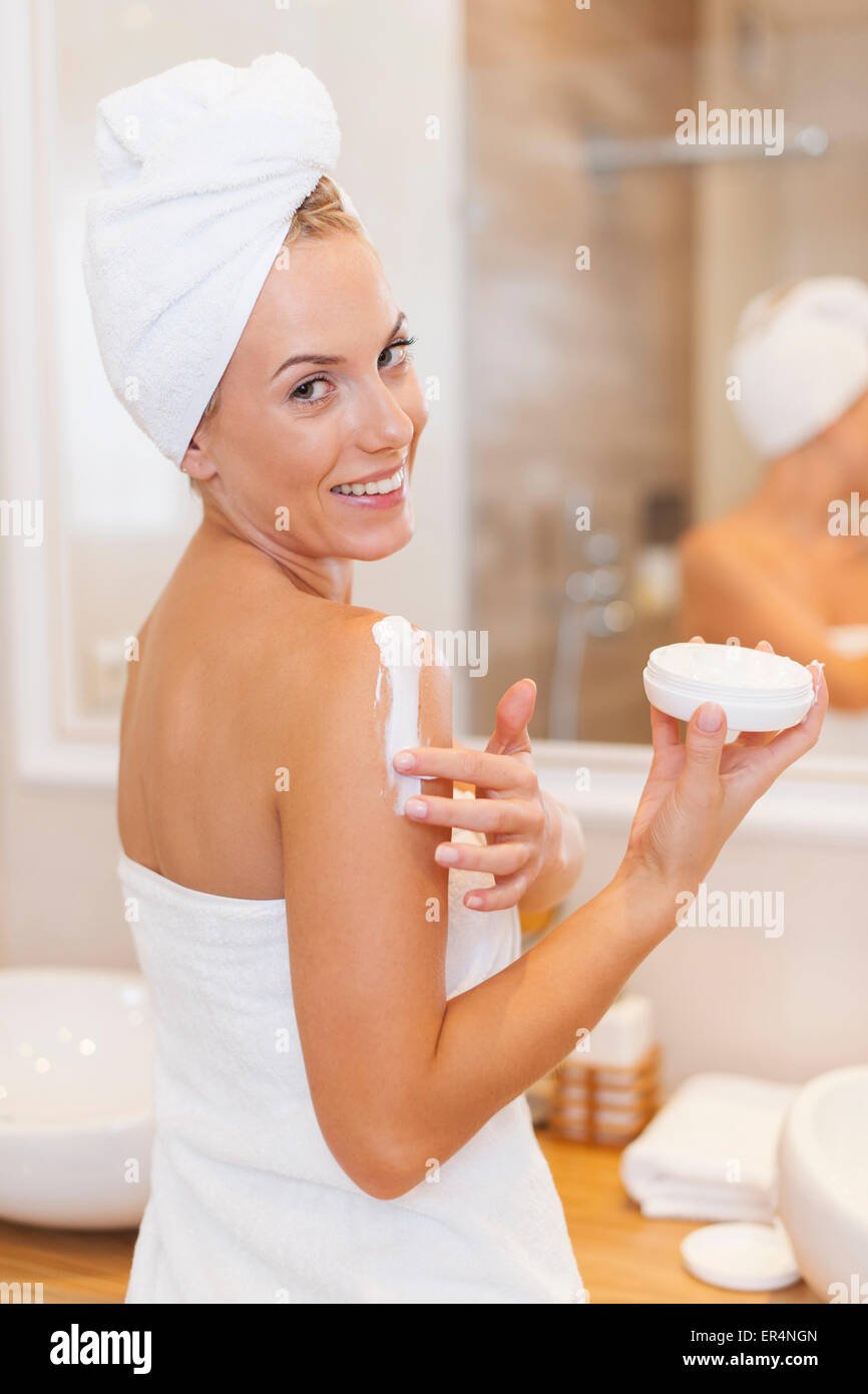 Woman moisturizes the body after the shower. Debica, Poland Stock Photo