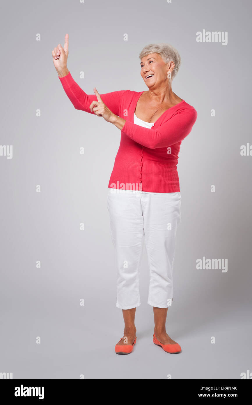 Older lady pointing to caption space Stock Photo