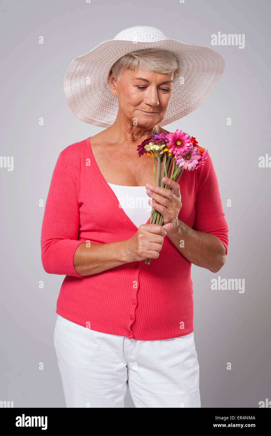 Older lady with flowers and a hat Stock Photo