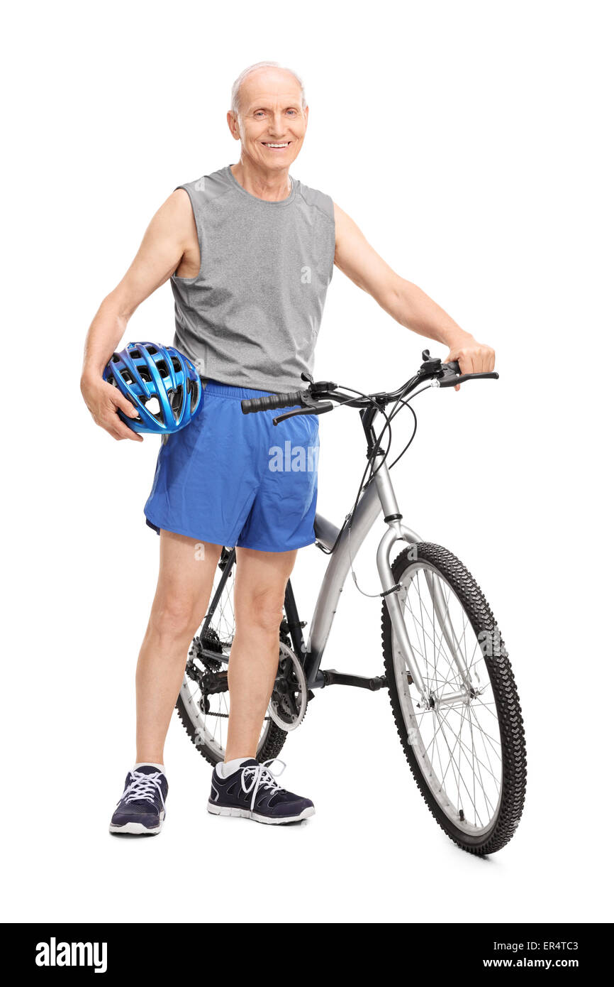 Full length portrait of an active elderly man holding a blue sports helmet and posing next to a bicycle Stock Photo