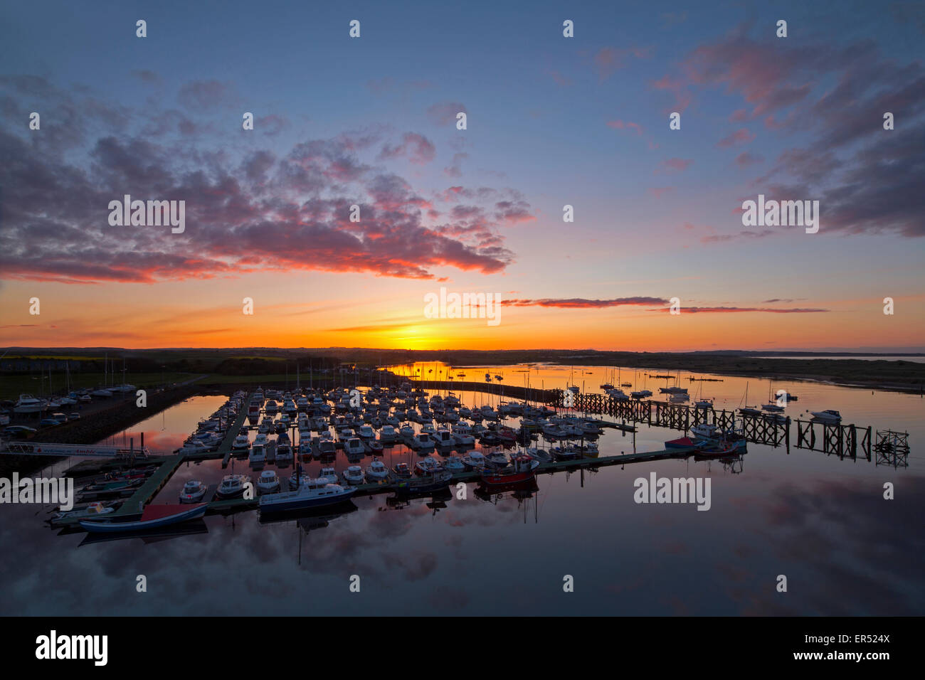A view of Amble marina in Northumberland in spring at sunset looking towards Warkworth village from an elevated viewpoint Stock Photo