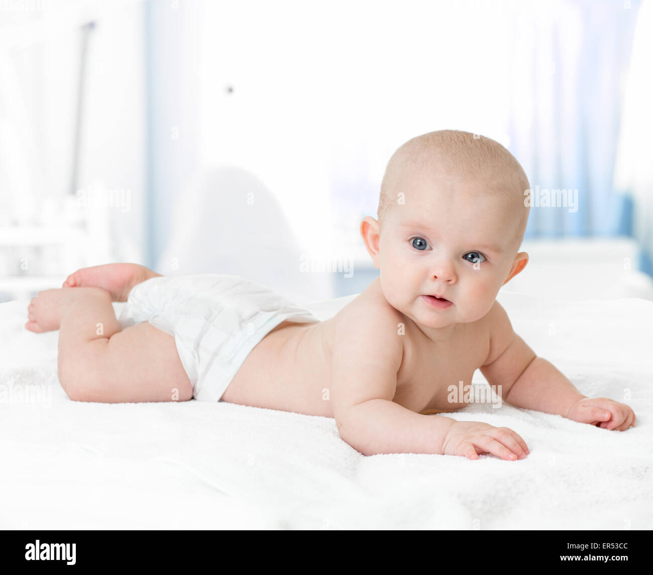 healthy baby lying on bed in bedroom Stock Photo