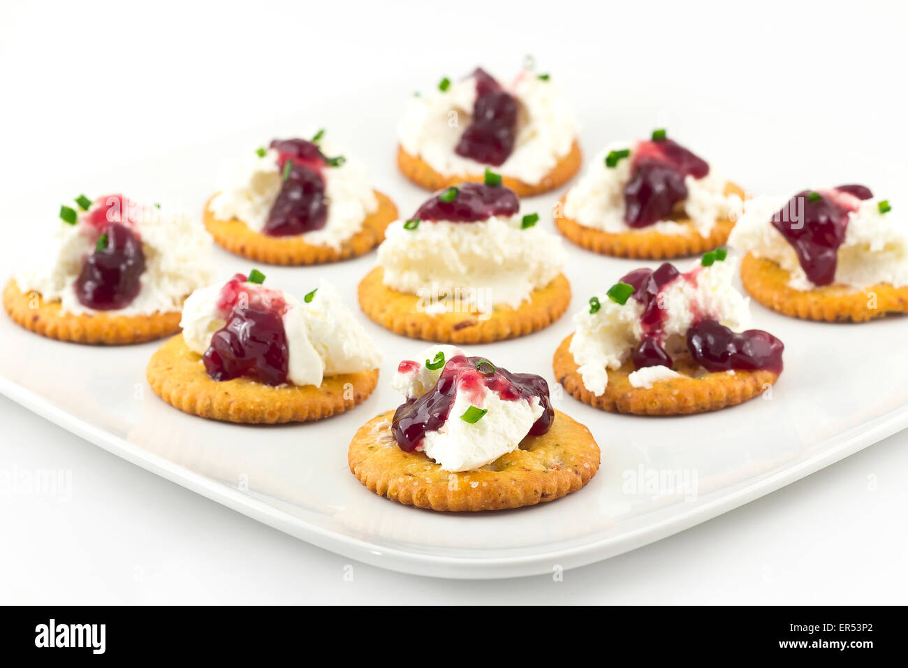 Snack plate of crackers topped with whipped cream cheese and grape