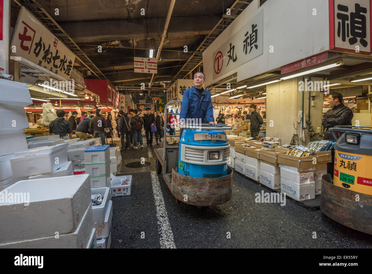 TOKYO, JAPAN - November, 22, 2014: A man driving taretto, motorized cargo cart, at Tsukiji, the biggest fish and seafood market Stock Photo
