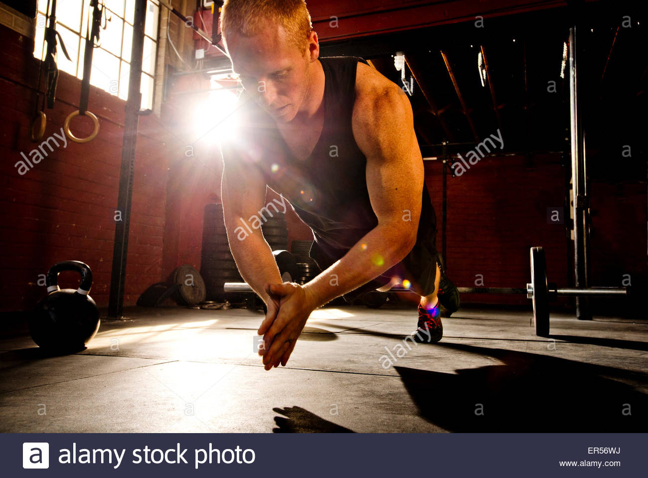 A crossfit athlete works out in a crossfit gym. Stock Photo