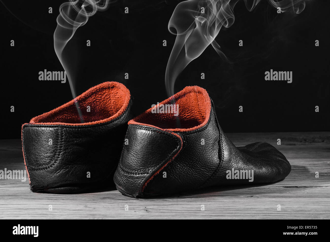 Empty slipper shoe design with smoke rise. Concept speed, smell, empty, leave. On black background with creative light. Stock Photo