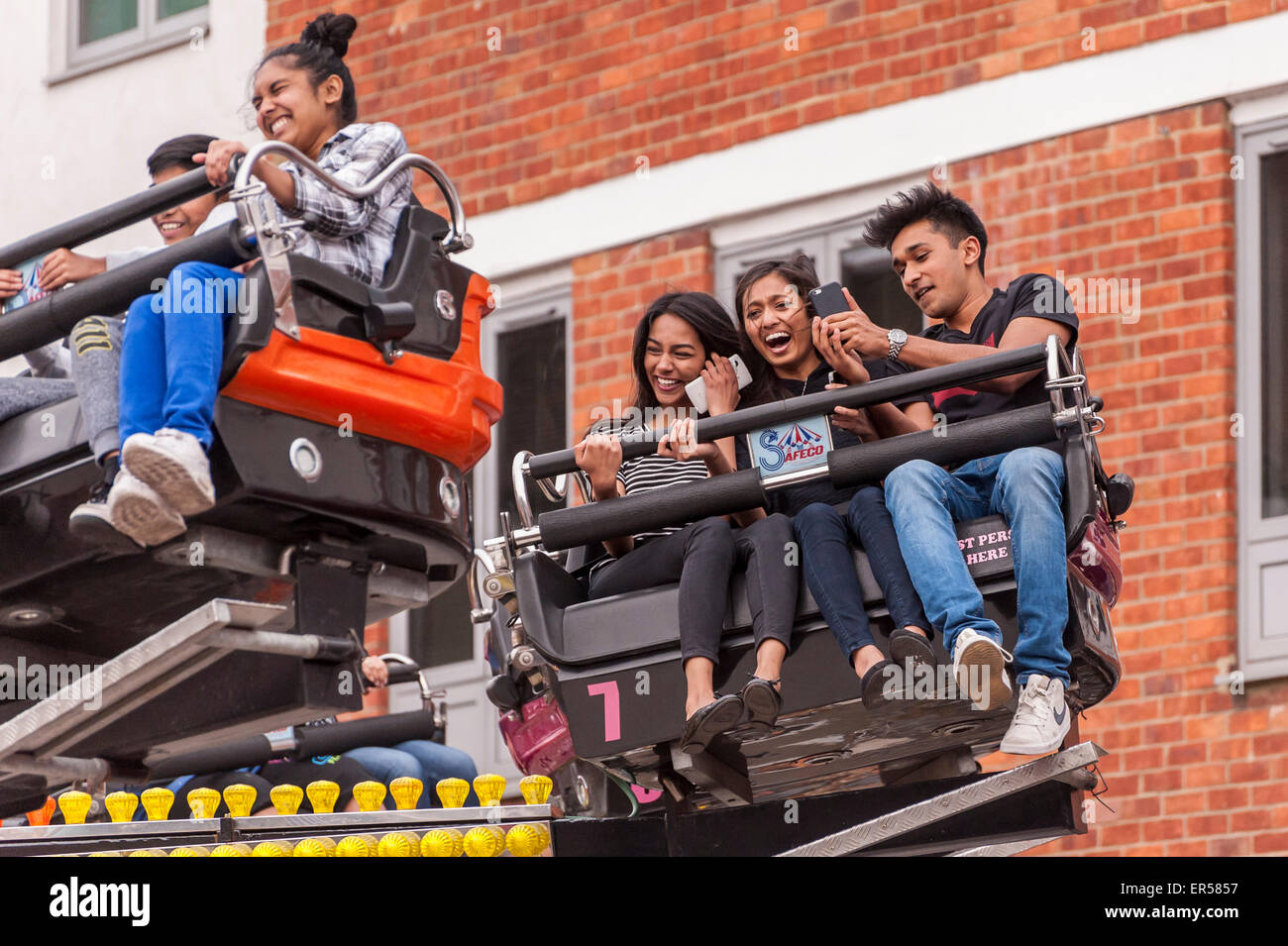 Pinner, London, UK. 27 May 2015. Children enjoy a spinning ride, as