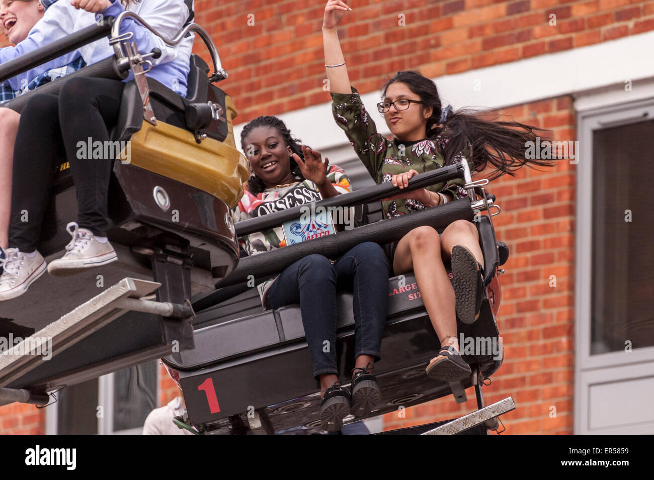 Pinner, London, UK. 27 May 2015. Children enjoy a spinning ride, as