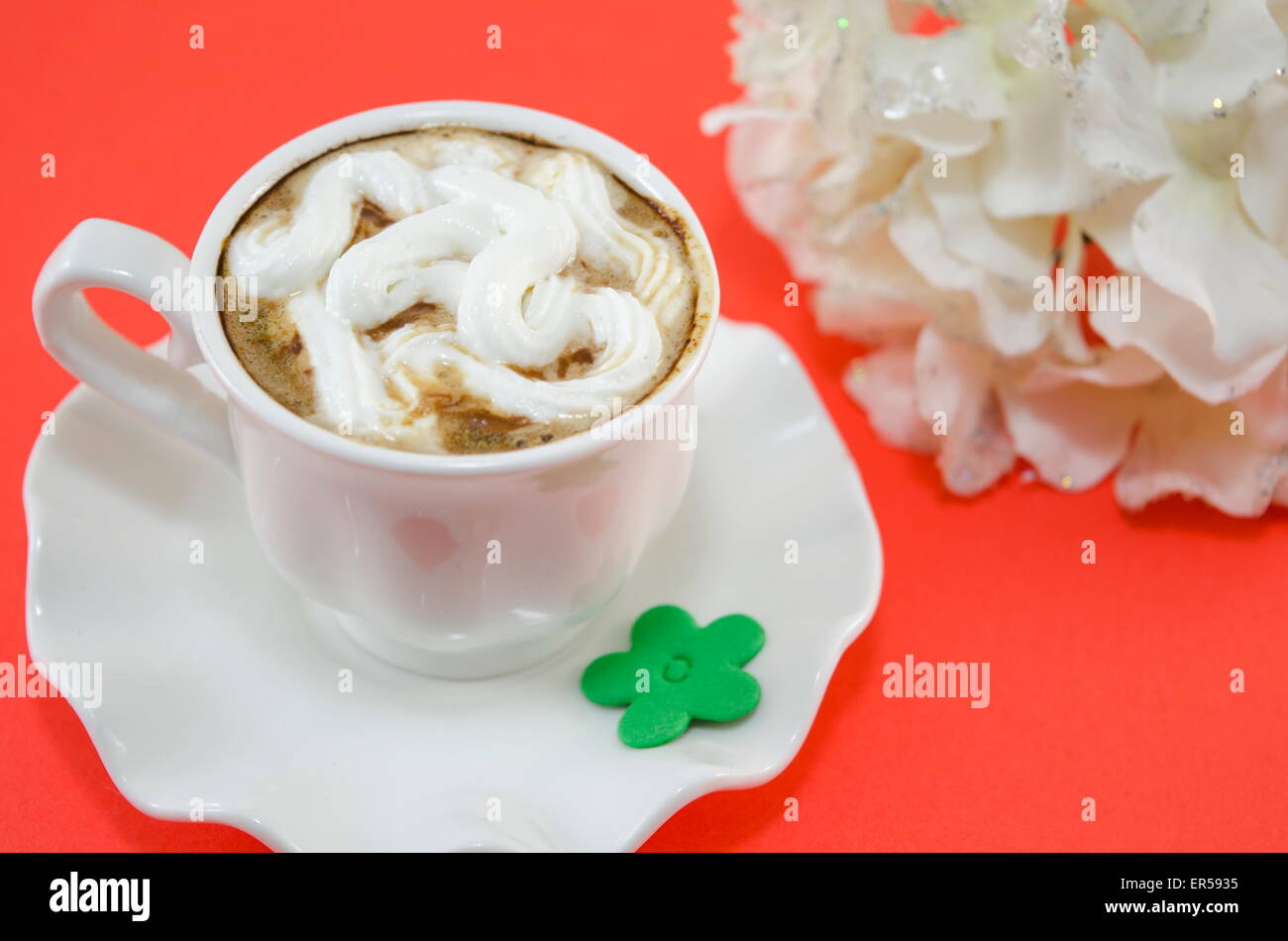 Cup of coffee with whipped cream on a red table Stock Photo