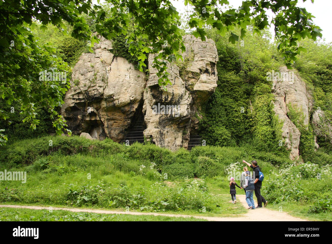 Visitors pass by caves at Creswell Crags, a limestone gorge on the border of Derbyshire and Nottinghamshire, Britain, UK Stock Photo