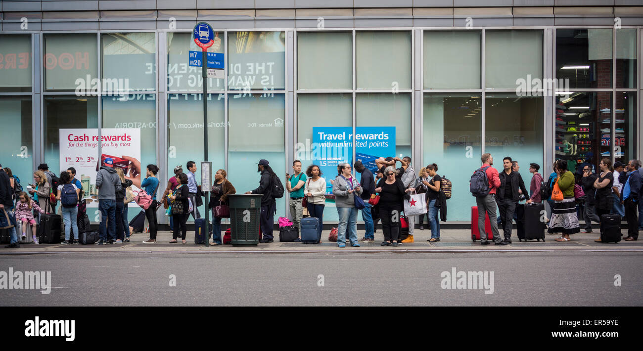 Travelers wait to board an inter-city bus in New York on Friday, May 22, 2015 to escape the city over the Memorial Day weekend. For those that drive, the weekend travel is estimated to be the busiest in ten years with 37 million expected to hit the road. (© Richard B. Levine) Stock Photo
