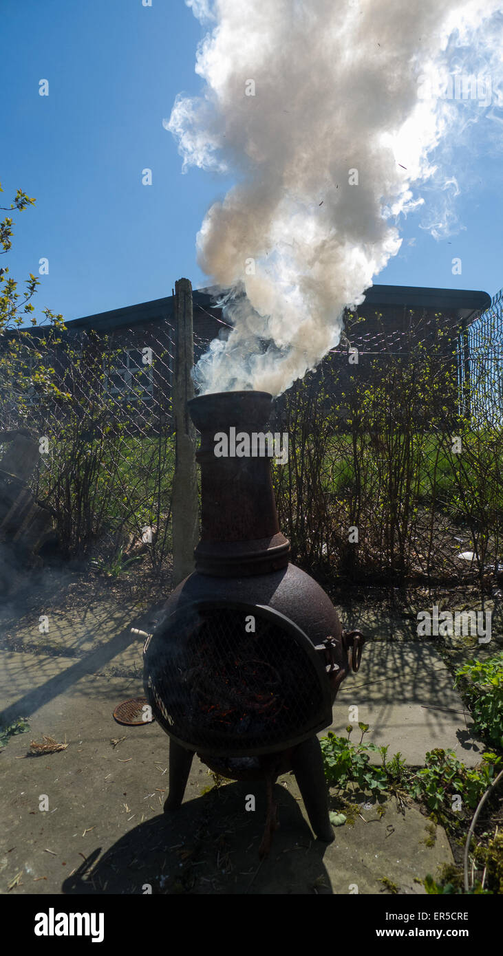 Smoking chiminea in domestic garden Stock Photo