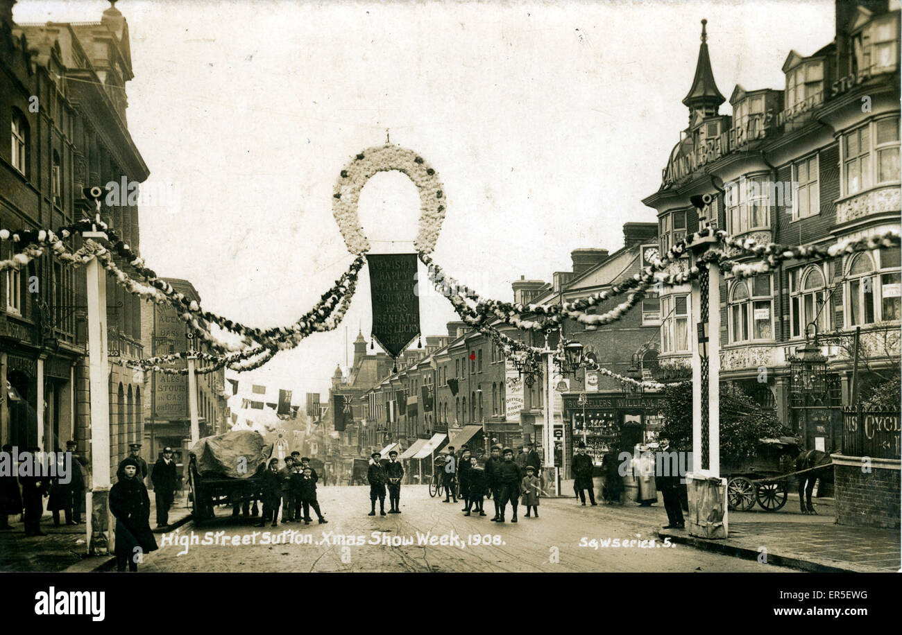 High Street, Sutton, near Croydon, Surrey, England. Showing the Christmas Show Week Celebrations. Also the shop/premises of Walsh Drapers, The Victoria Wine Company and Freeman Hardy Willis  1908 Stock Photo