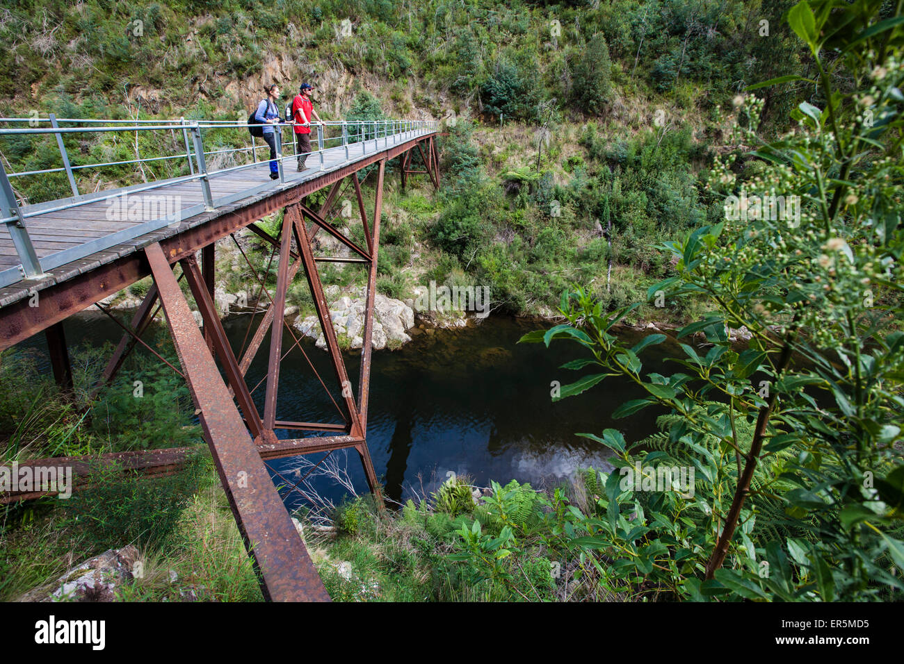 Couple standing on an old railway bridge over the Thomson River, Walhalla, Victoria, Australia Stock Photo