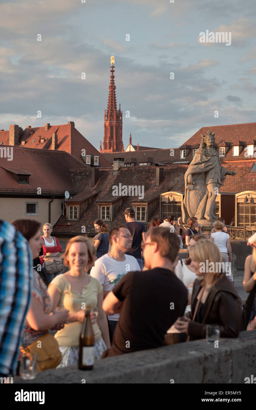 View across the old Main bridge to St. Mary's chapel, young people drinking wine at sunset, Wuerzburg, Franconia, Bavaria, Germa Stock Photo