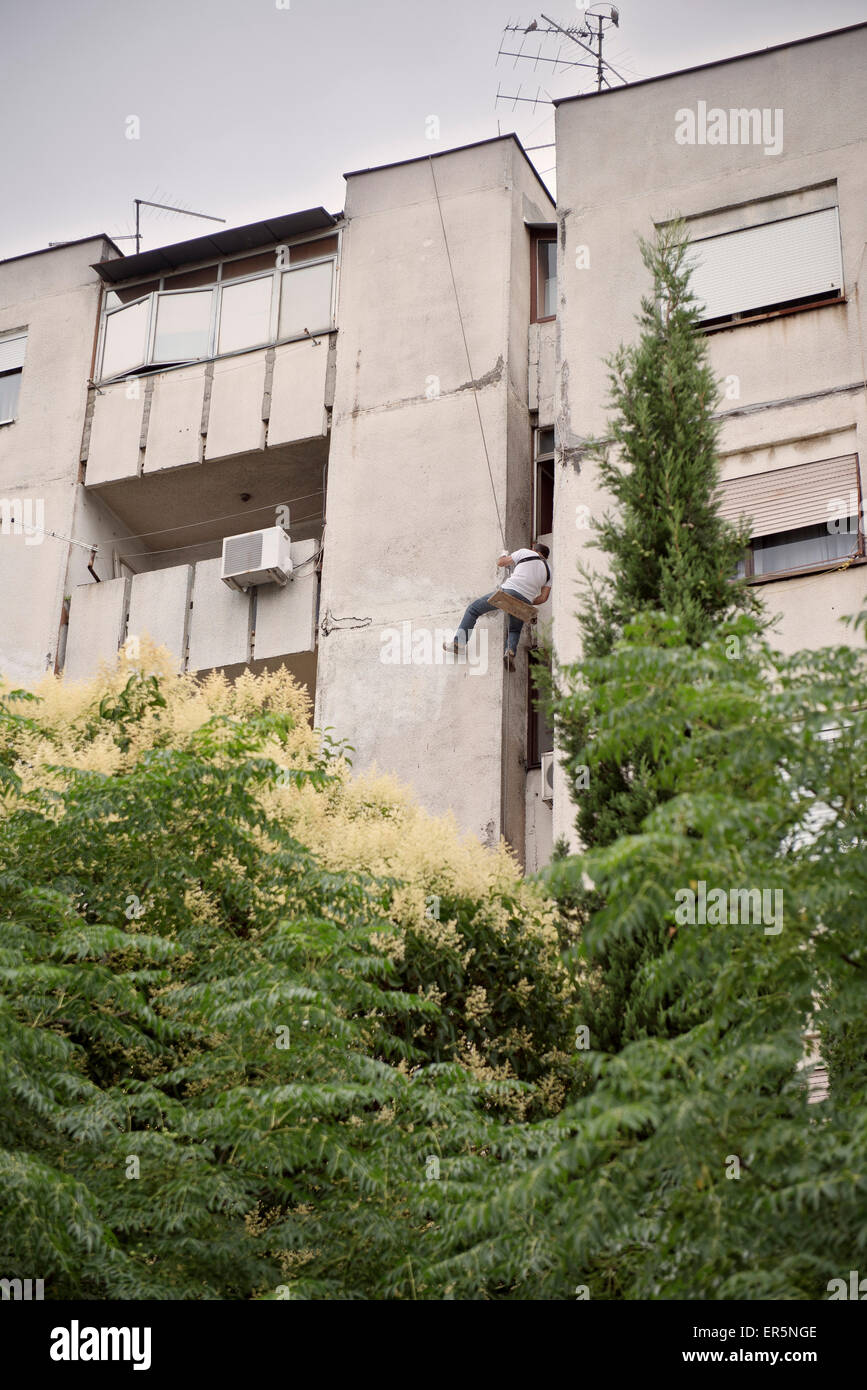 Man hanging from a rope on the house fascade, capital Podgorica, Montenegro, Western Balkan, Europe Stock Photo