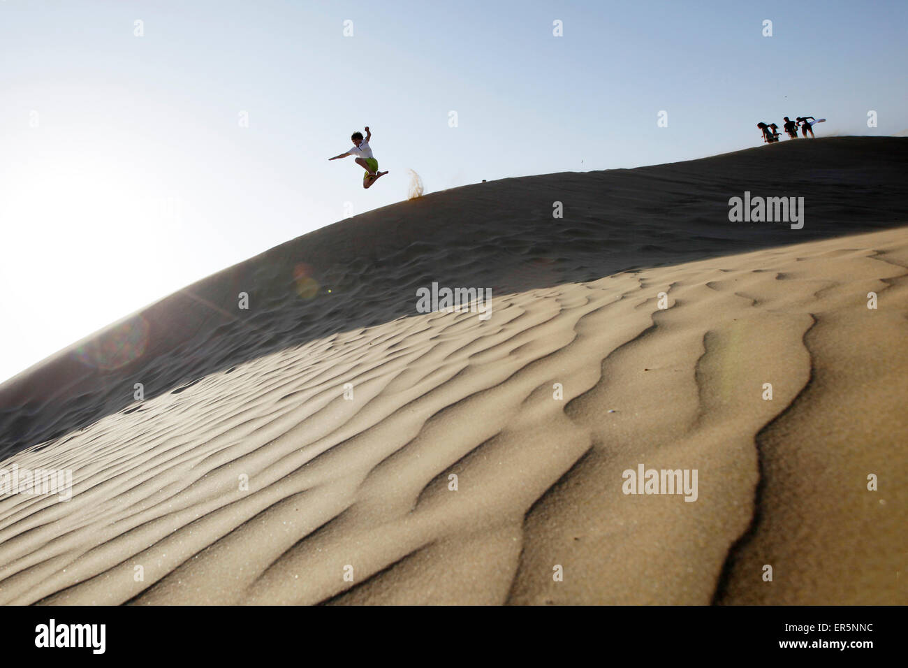 Boy jumping from a sand dune, Agadir, Morocco Stock Photo