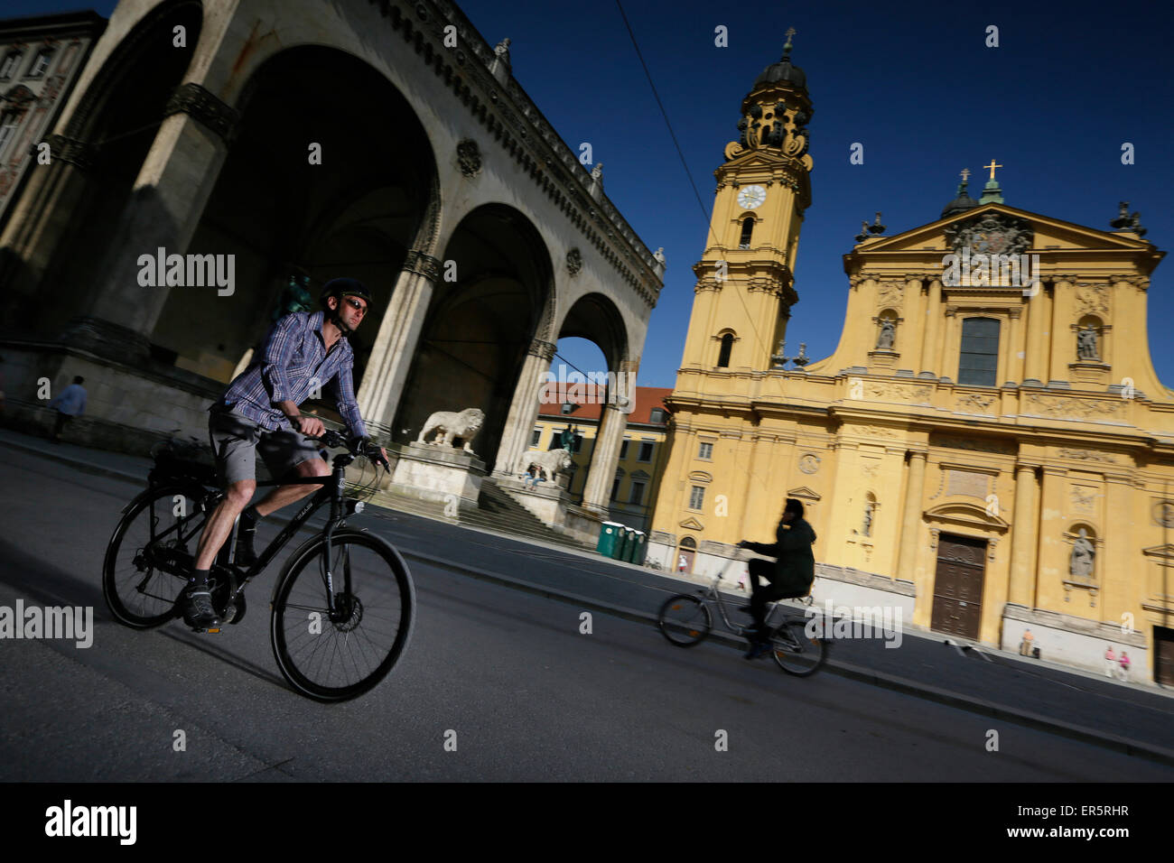 Man with an e-bike crossing Odeonsplatz, Munich, Upper Bavaria, Germany Stock Photo