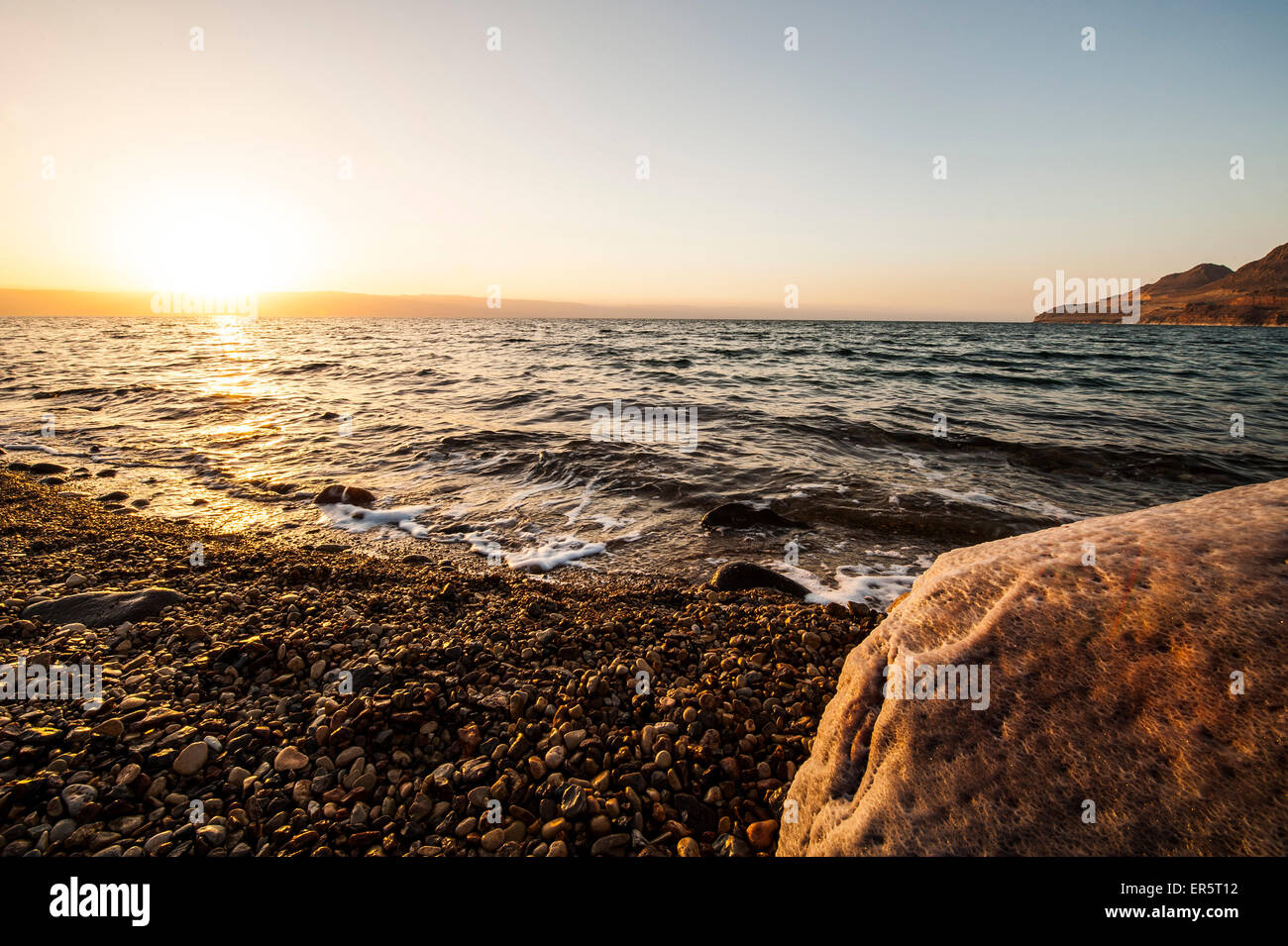 Salt encrusted stone in dead sea at sunset, Jordan, Middle East Stock Photo
