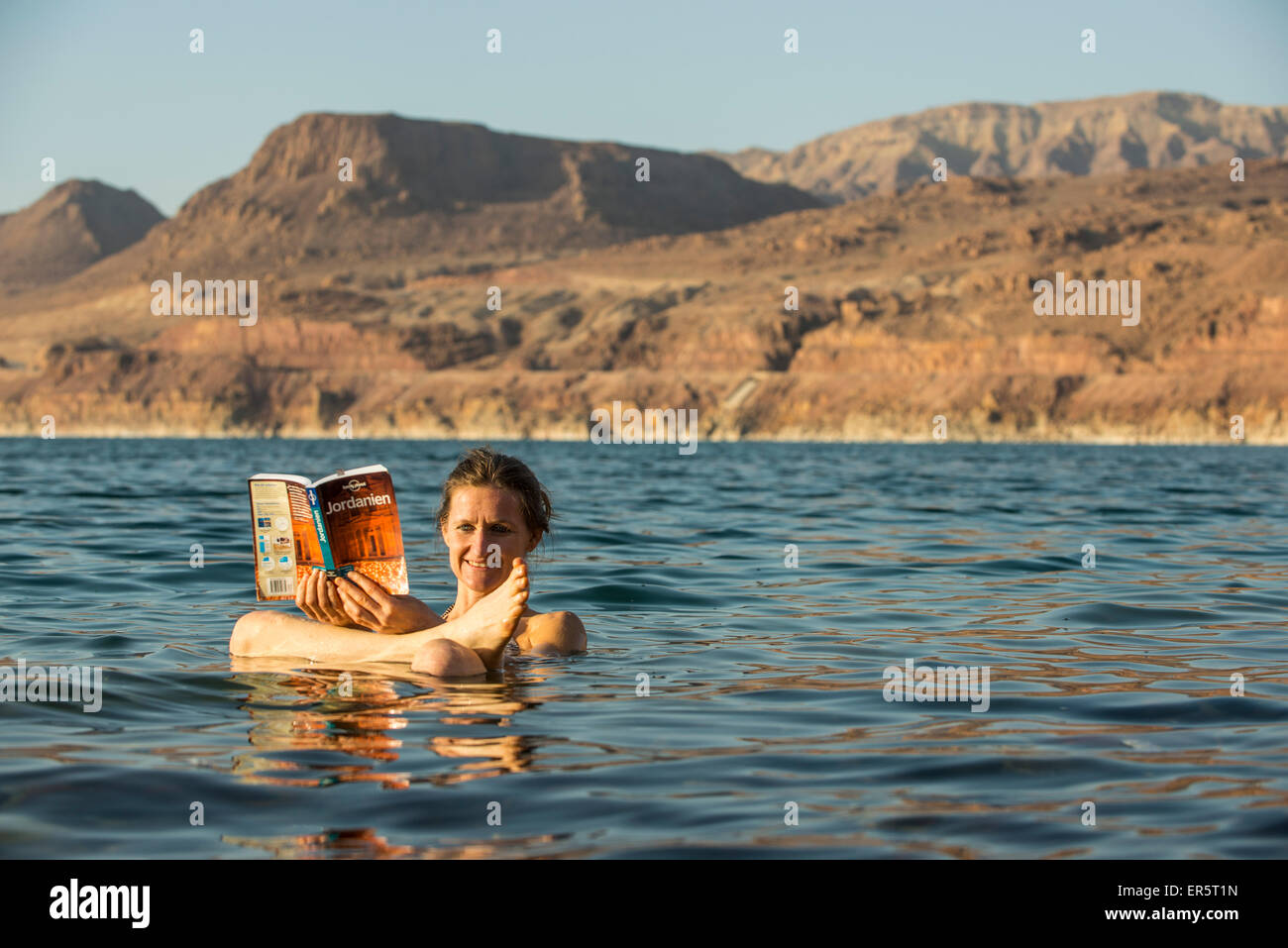 Woman reading a guidebook in Dead Sea, Jordan, Middle East Stock Photo