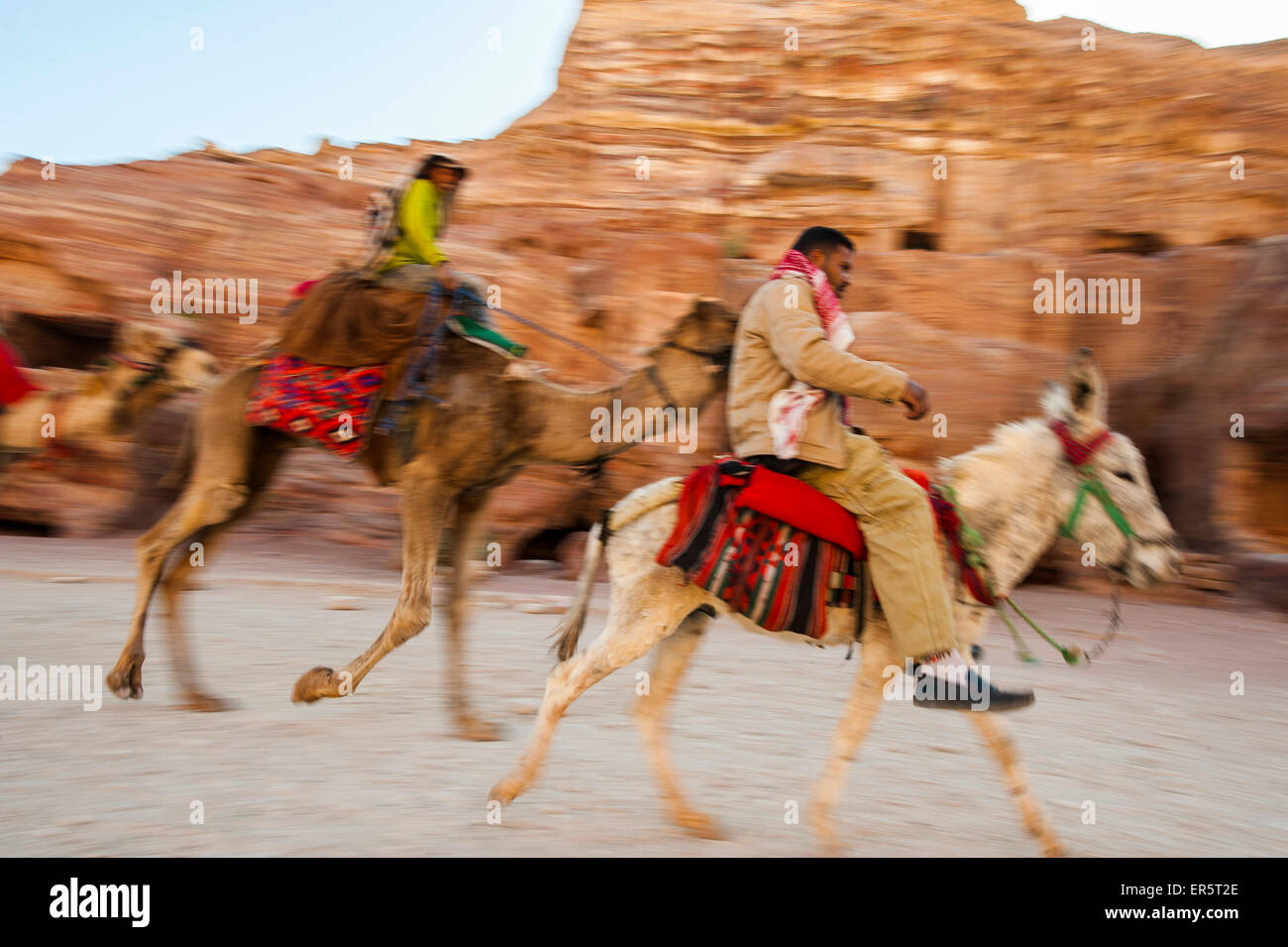 Men riding on a camel and a donkey, Petra, Jordan, Middle East Stock Photo