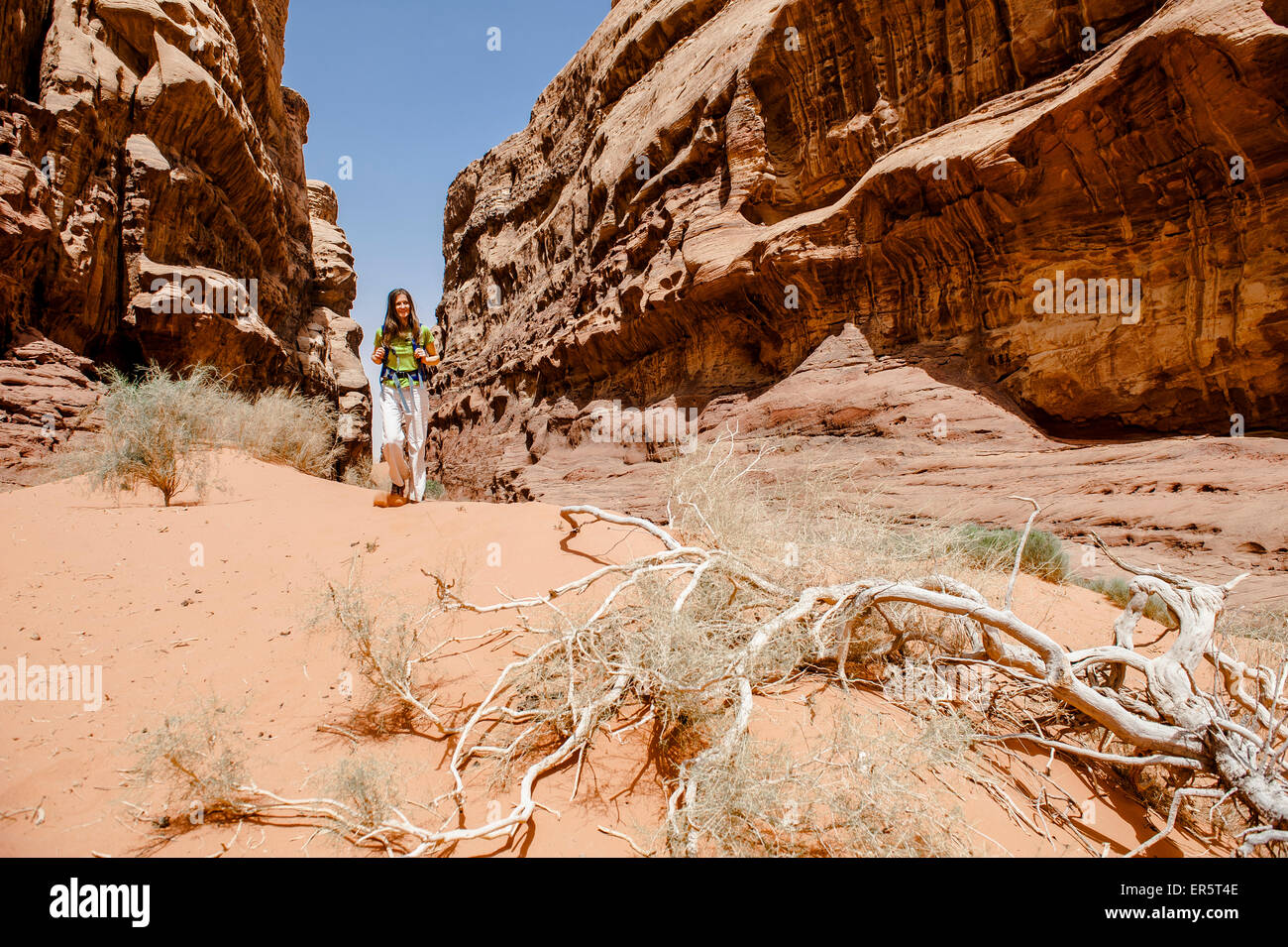 Woman hiking through a gorge, Wadi Rum, Jordan, Middle East Stock Photo