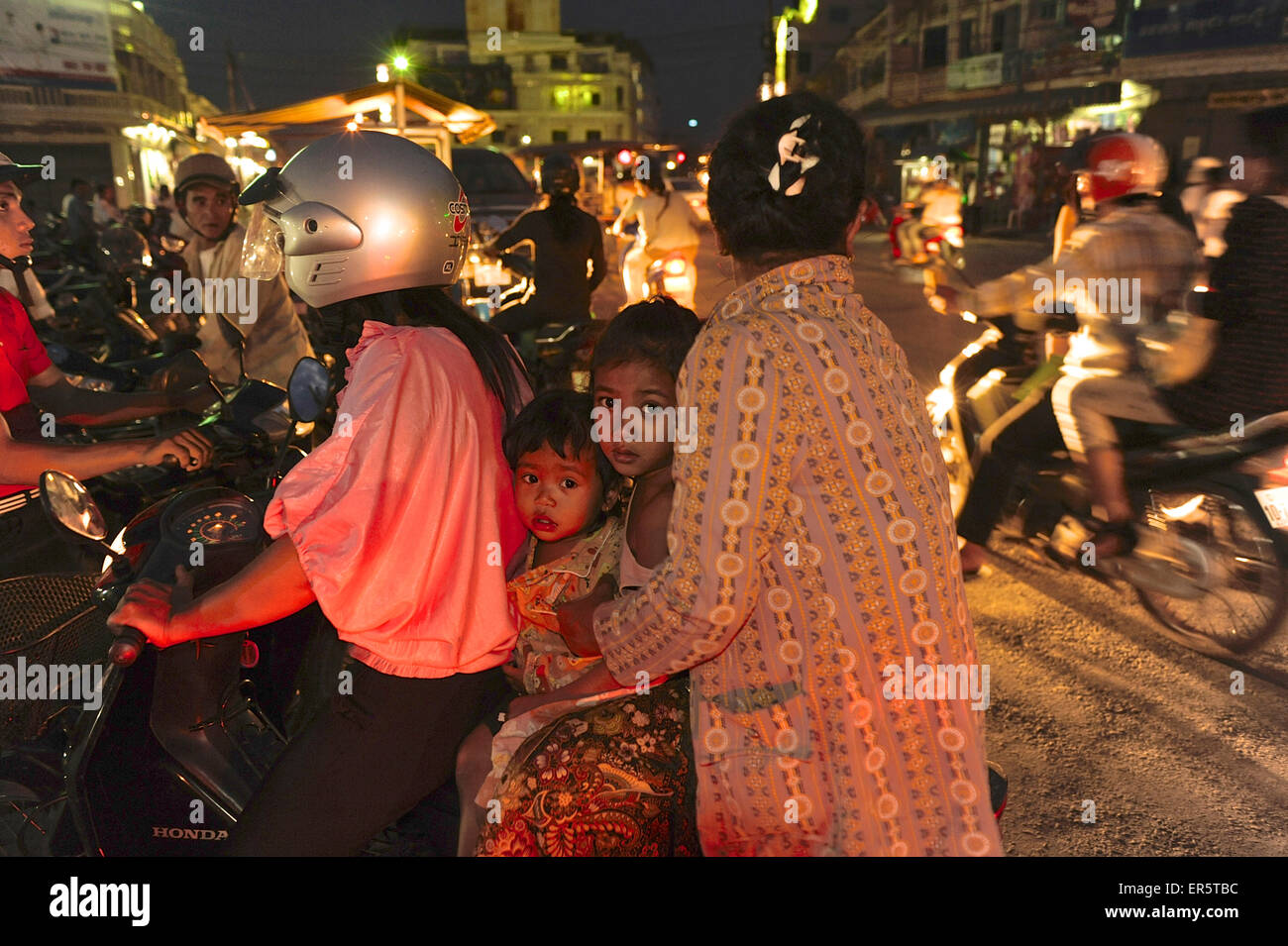 Two women with two children sitting on one motorscooter in the center of Battambang, Cambodia, Southeast Asia Stock Photo
