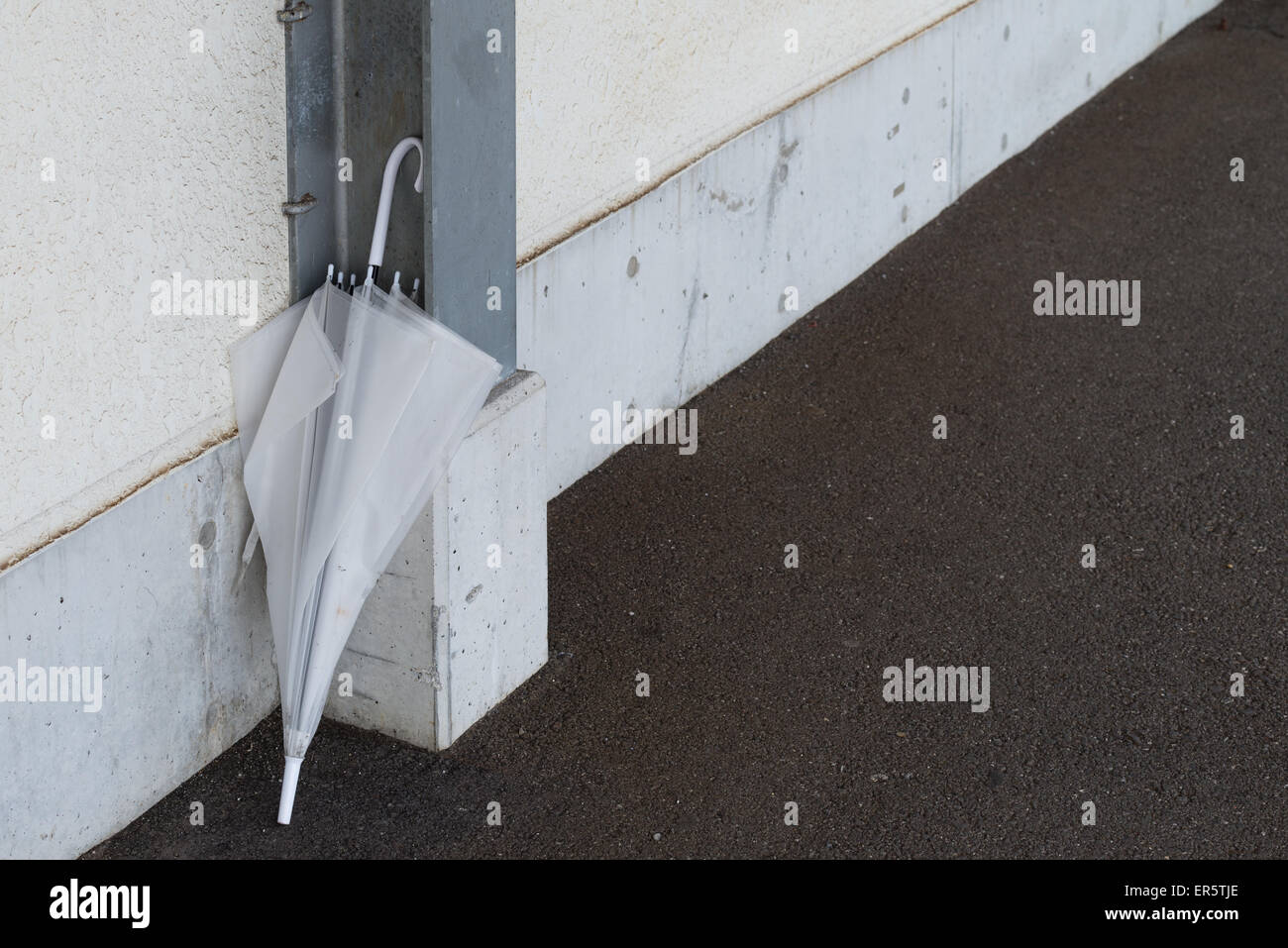 A dirty old forgotten umbrella at a train station. Stock Photo