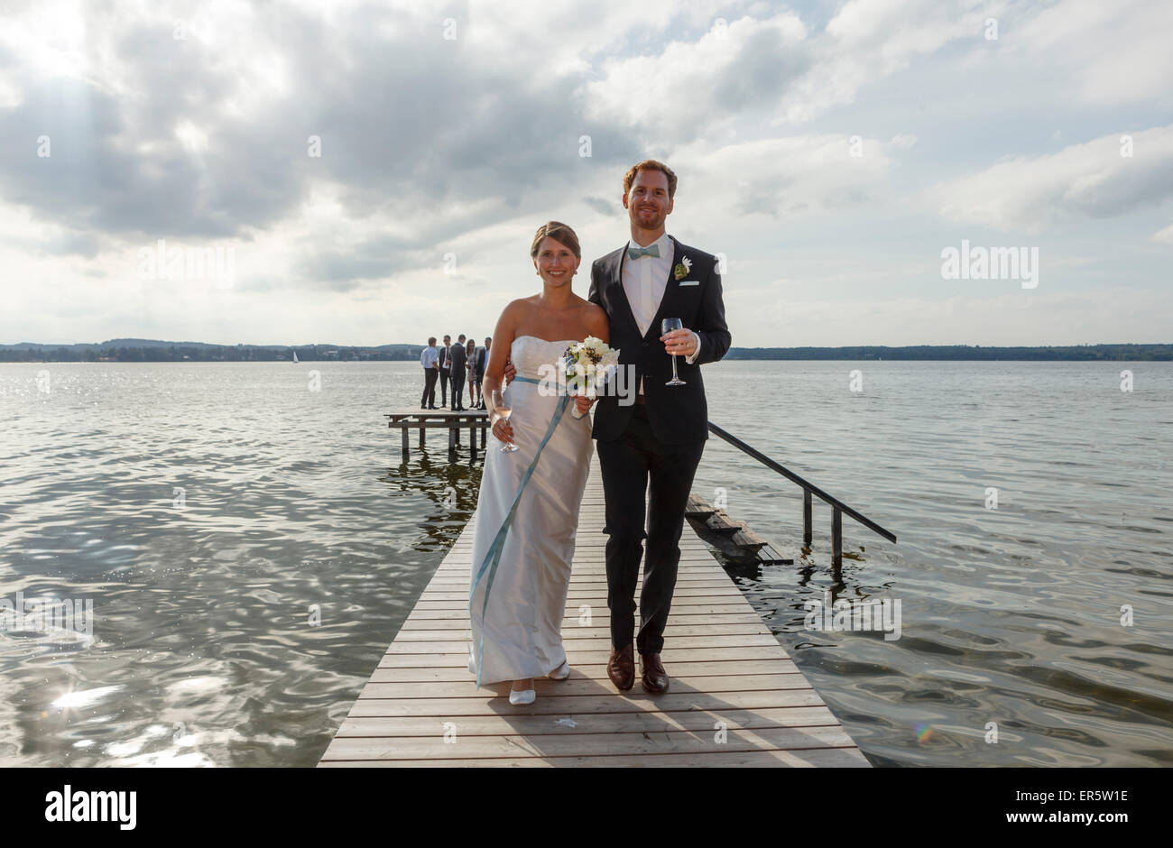 Bridal couple is walking along the jetty, Starnberger See, Bavaria, Germany Stock Photo