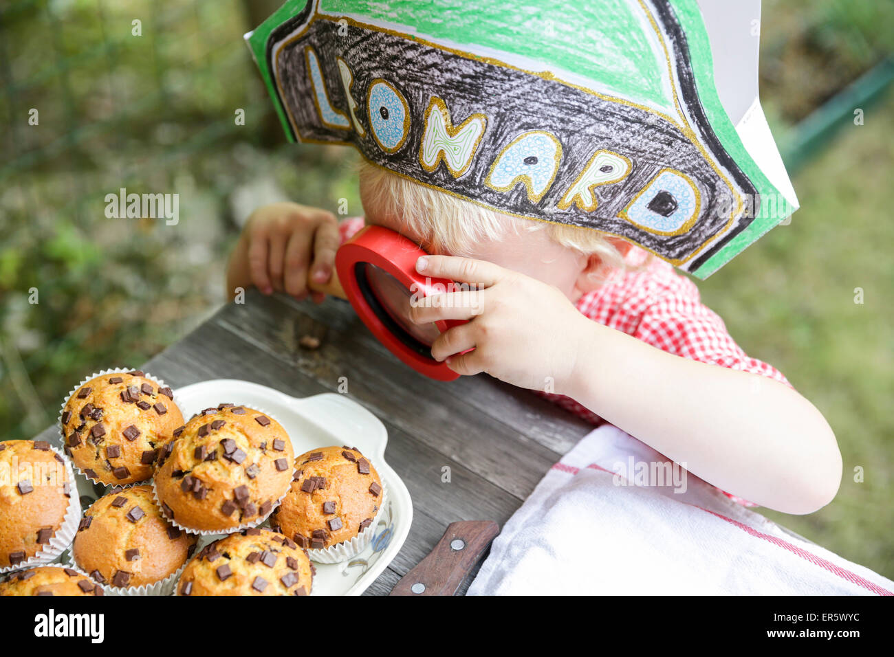 Boy keeping a close eye on muffins, Leipzig, Saxony, Germany Stock Photo