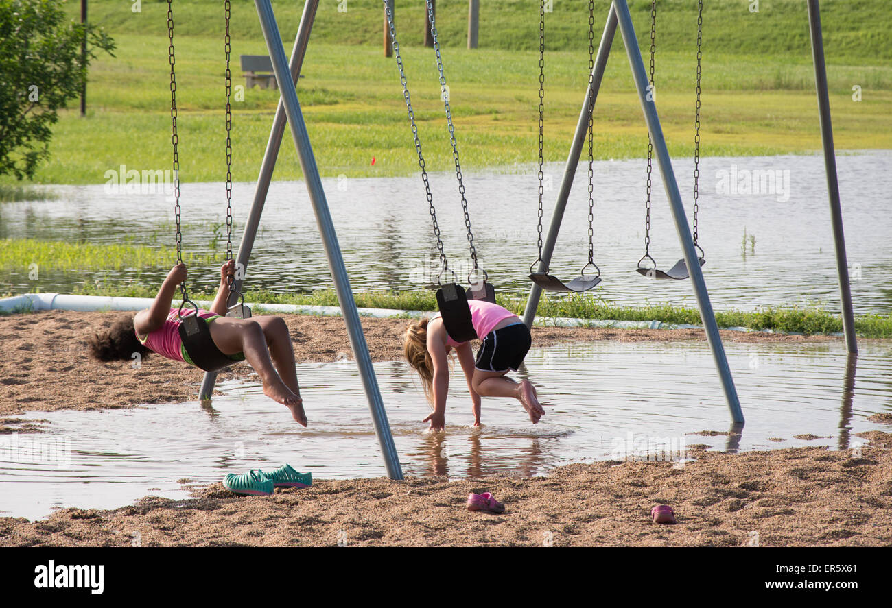 Mannford, Oklahoma, USA. 27th May, 2015. Children are playing on public playground inundated with flood waters in Mannford, Oklahoma on Wednesday 27th May, 2015. Oklahoma has experienced record breaking rains in May, leading to wide-spread flooding. Credit:  Sari O'Neal/Alamy Live News Stock Photo