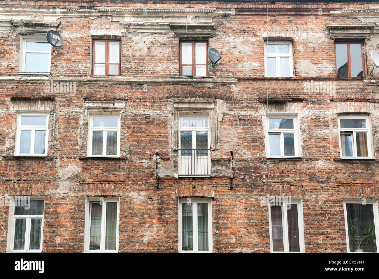Exterior of an occupied brick apartment building left over from Communist time period when all decorations were removed, Warsaw Stock Photo