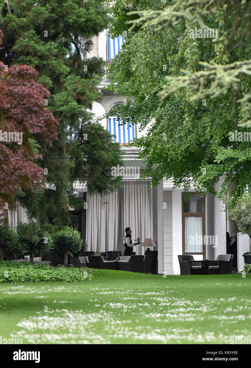 Zurich, Switzerland. 27th May, 2015. Terrasse and facade of star hotel Baur Au Lac in Zurich seen through the hotel's idyllic litte park near the lake. Credit:  thamerpic/Alamy Live News Stock Photo