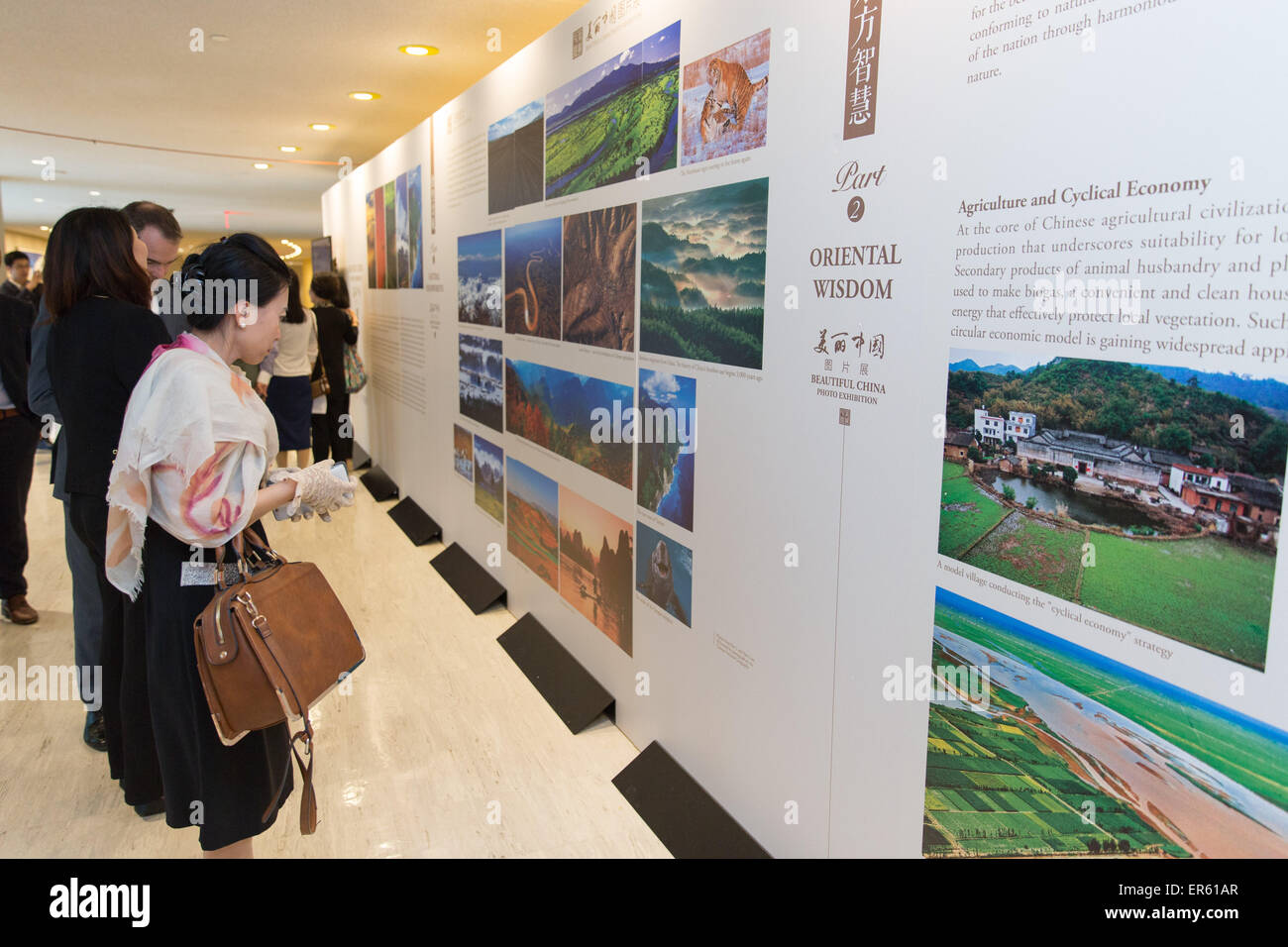 New York, USA. 27th May, 2015. People look at photos during the 'Beautiful China' photo exhibition at the United Nations headquarters in New York, the United States, on May 27, 2015. The 'Beautiful China' photo exhibition, a major event of the BookExpo America (BEA) 2015, opens on Wednesday at the United Nations headquarters in a bid to showcase China's natural beauty and cultural heritage. © Li Muzi/Xinhua/Alamy Live News Stock Photo