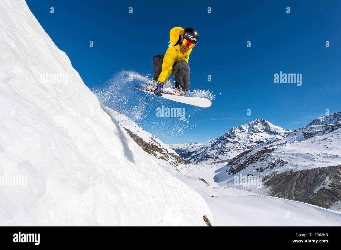 Snowboarder jumping in deep snow, Val Roseg, Pontresina, Canton of Graubünden, Switzerland Stock Photo