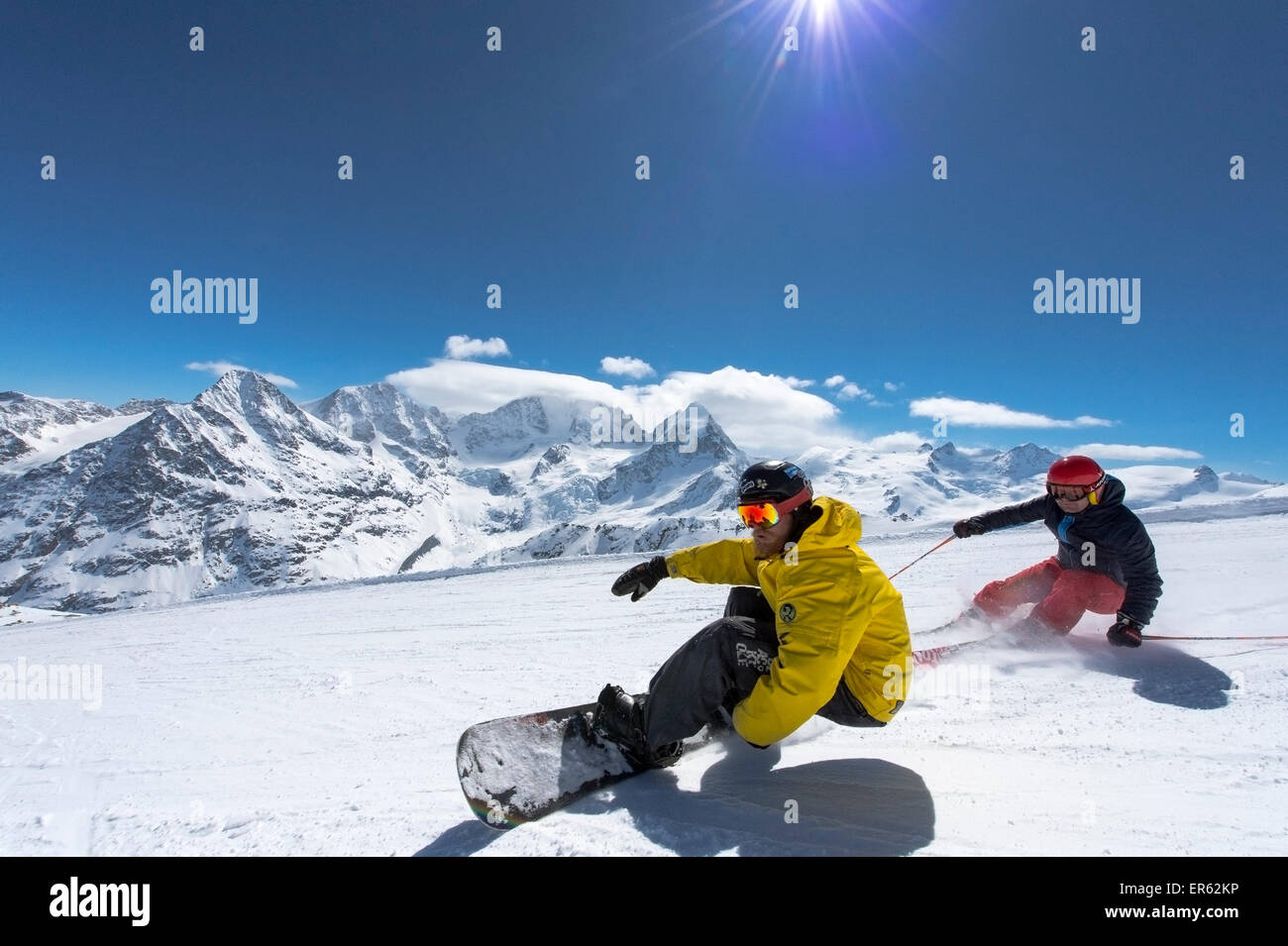 Skier and snowboarder, the Bernina massif behind, Corvatsch, Silvaplana, Canton of Graubünden, Switzerland Stock Photo