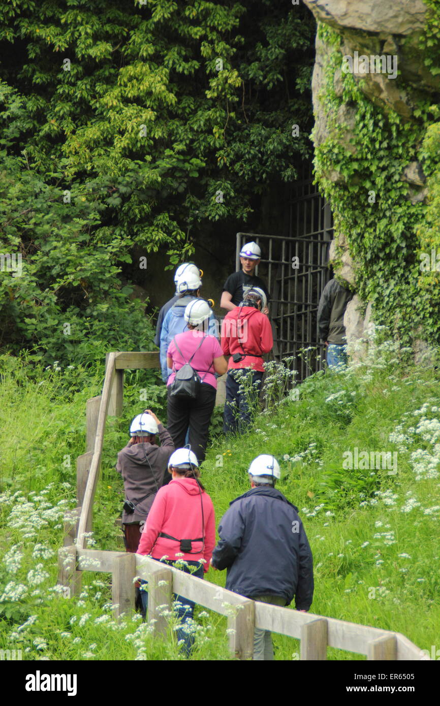 Visitors enter a cave during a tour of Creswell Crags on the border of