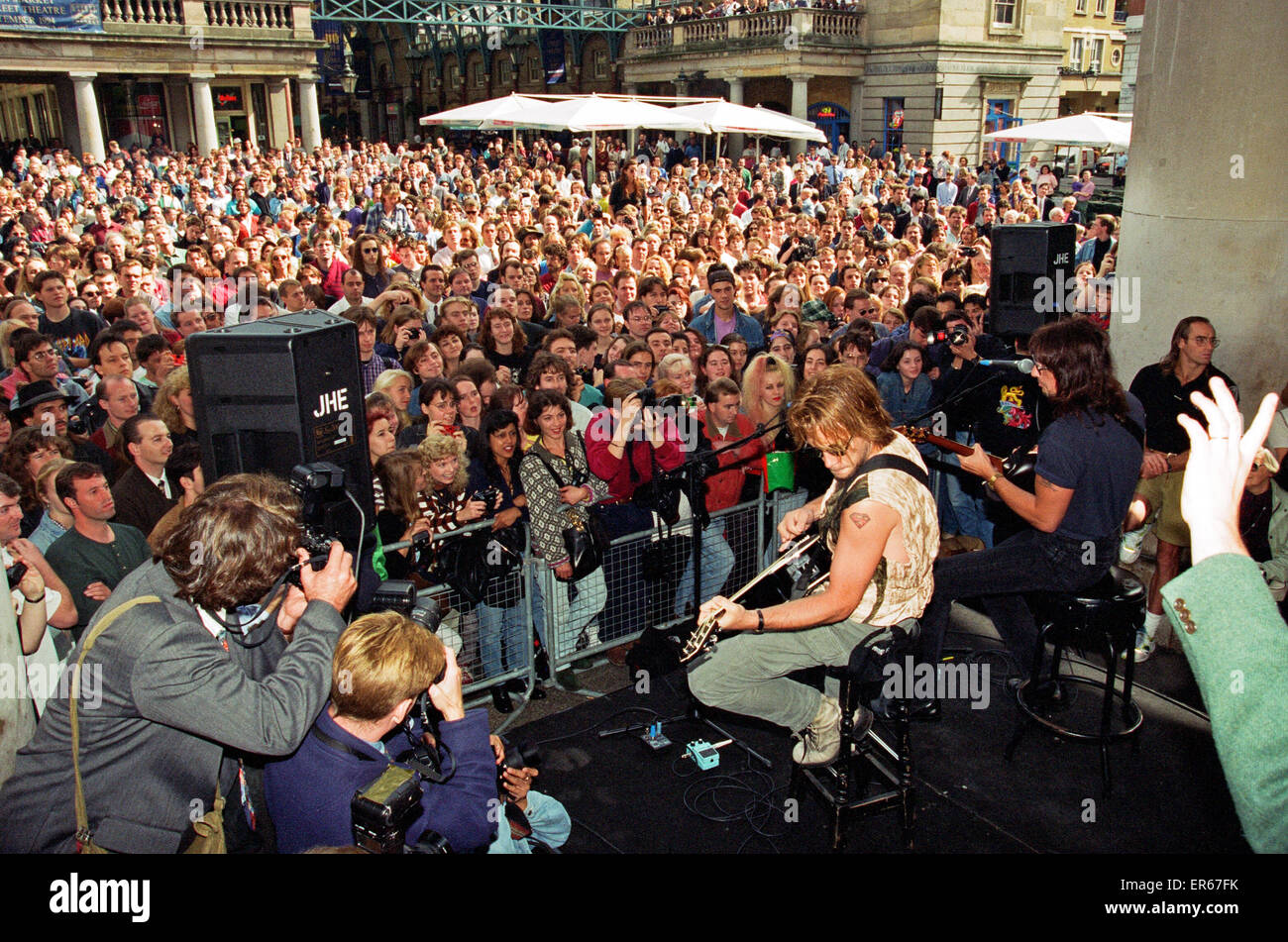 Jon Bon Jovi, lead singer of rock group Bon Jovi, busking in Covent Garden, London - and vowed a crowd of 5,000, 7th September 1994. Jubilant fans completely blocked the historic piazza as the heavy metal idol and his lead guitarist Richie Sambora belted Stock Photo